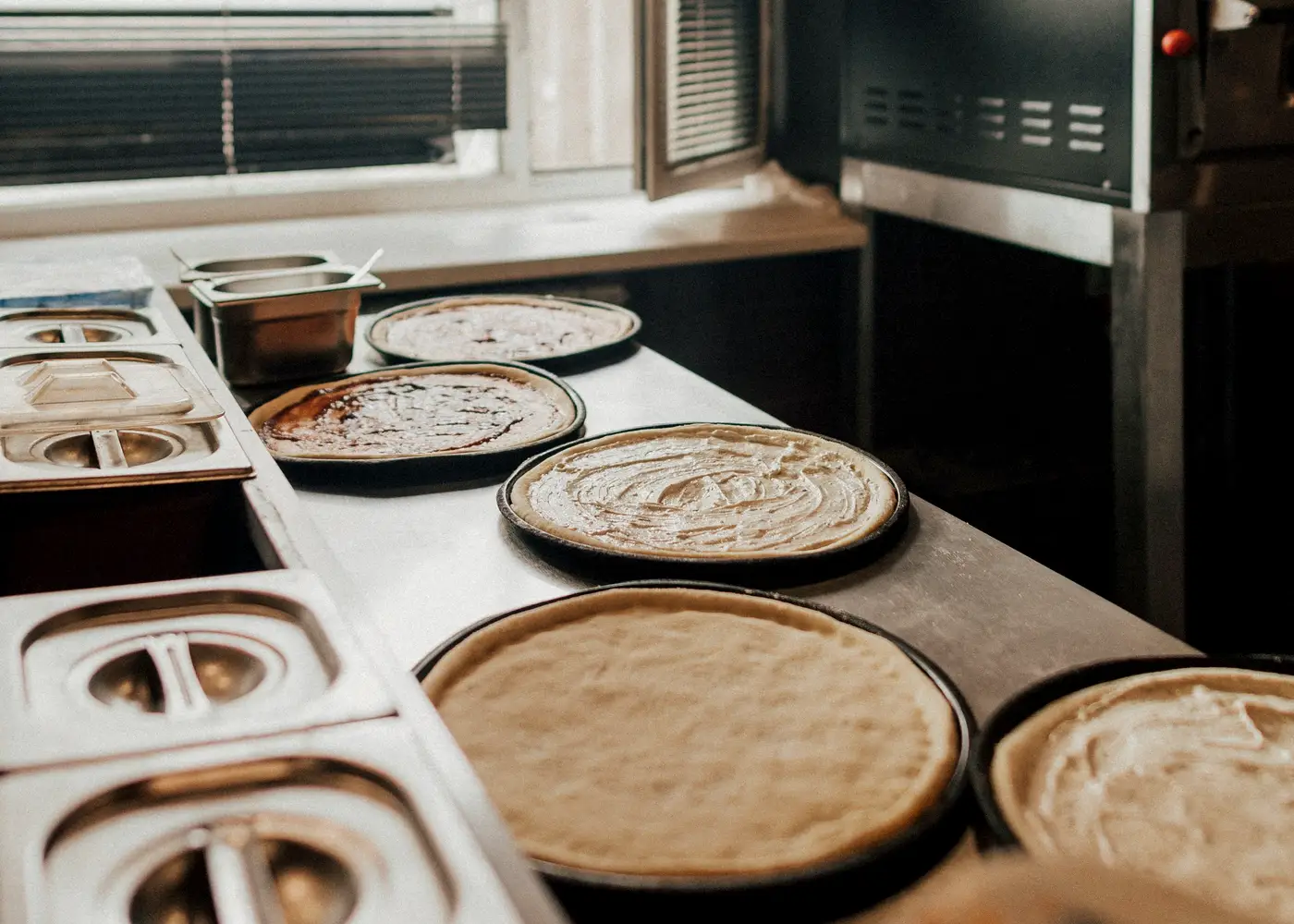 Fresh pizza dough prepared on a work counter
