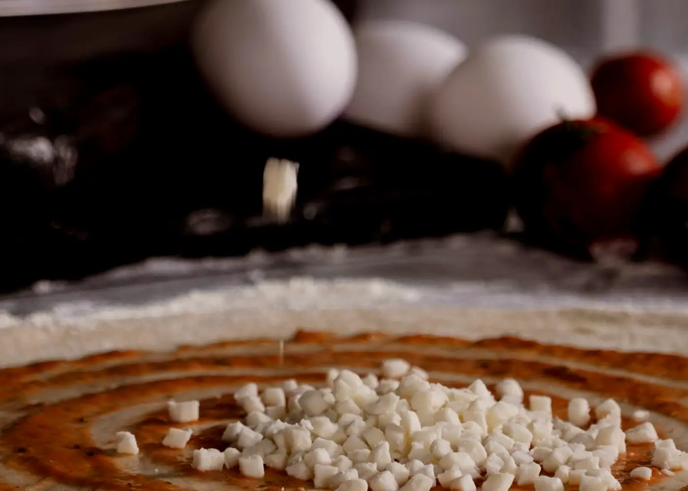 Sauce being spread over pizza dough